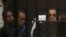 El expresidente egipcio Hosni Mubarak escuchó desde una camilla en una jaula la decisión del juez que lo exoneró de cargos. Su hijo Gamal, segundo de la izquierda también fue exonerado.