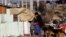FILE - A woman and her daughter stand outside their shack in a slum of Villa Fiorito, on the outskirts of Buenos Aires, Argentina, June 15, 2016.