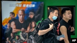 People walk past a poster for the movie ‘Fast & Furious 9’ at a shopping mall in Beijing, May 26, 2021, while pro-wrestling champion and actor John Cena is apologizing after calling Taiwan a country in promotional interviews for his film.
