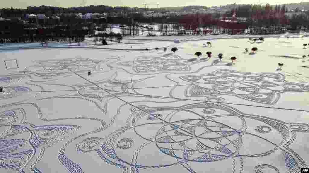 An aerial photograph shows a snow drawing made entirely of footprints on a golf course outside the Finnish capital Helsinki, in Espoo, Feb. 10, 2021.