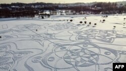 An aerial photograph shows a snow drawing made entirely of footprints on a golf course outside the Finnish capital Helsinki, in Espoo on February 10, 2021.