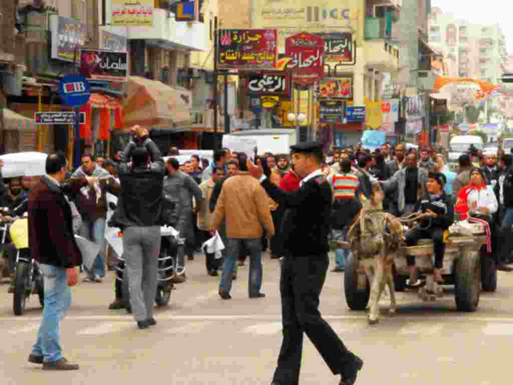 Seorang polisi memberi jalan bagi pejalan kaki di Port Said, sehari setelah kerusuhan di kota ini (2/2) (A. Ekimian).