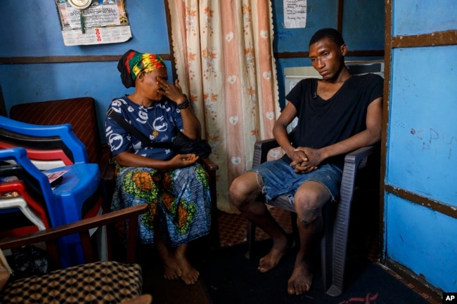 Memunatu Kamara breaks down in tears next to her son Mohammed, who smokes Kush in Susan's Bay, one of the three largest slums in Freetown, Sierra Leone, Sunday, April 28, 2024. (AP Photo/ Misper Apawu)