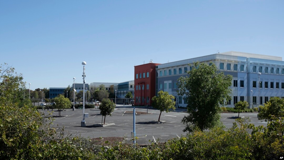FILE - A nearly empty parking lot is shown at Facebook headquarters in Menlo Park, Calif., April 14, 2020. Tech companies have sent home human moderators and must rely on automated systems.