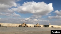 FILE - Military vehicles of U.S. soldiers are seen at the Al-Asad Air Base in Anbar province, Iraq, Jan. 13, 2020. "Multiple ballistic missiles and rockets" were fired by Iran-backed militants at Al-Asad Air Base in western Iraq on Jan. 20, 2024, the U.S. military said.