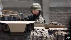 FILE - A US forces soldier guards the site after a suicide bombing attack near Kabul's international airport in Kabul, Afghanistan, May 17, 2015.