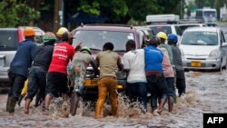 Des passants poussent un véhicule à Dar es Salaam, Tanzanie, le 23 novembre 2016.