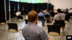 FILE - Georgia Tech employee Adam Jackson waits after receiving a Pfizer COVID-19 vaccination at the Vaccination Site on the campus of Georgia Tech, April 8, 2021 in Atlanta. 