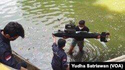 Sekelompok mahasiswa Universitas Sebelas Maret (UNS) Solo melakukan uji coba drone kapal selam buatan mereka di area danau kampus pada 18 Oktober 2021. (Foto: VOA/Yudha Satriawan)