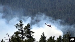 FILE - The U.S. Forest Service shows a helicopter fighting a wildfire in Coconino National Forest in Arizona, April 30, 2018. Visitors at the park have been asked to evacuate after a fire in the state grew to more than 400 hectares on July 22, 2019.