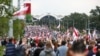 Belarusian opposition supporters with old Belarusian national flags gather toward the Independence Palace, the residential of Belarusian President Alexander Lukashenko in Minsk, Belarus, Sept. 6, 2020.