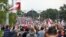 Belarusian opposition supporters with old Belarusian national flags gather toward the Independence Palace, the residential of Belarusian President Alexander Lukashenko in Minsk, Belarus, Sept. 6, 2020.