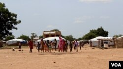 Malian children return from morning primary school session, which they attend in neighboring village, Sag-Nioniogo refugee camp, Burkina Faso, Oct. 9, 2013. (VOA/Jennifer Lazuta)