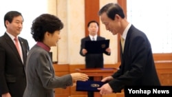 박근혜 한국 대통령이 25일 청와대에서 김장수 청와대 국가안보실장에게 임명장을 주고 있다.