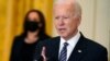 El presidente Joe Biden, en primer plano, se dirige a la nación desde la Casa Blanca, ante la atenta mirada de la vicepresidenta Kamala Harris, al fondo y con mascarilla, el 18 de marzo de 2021.