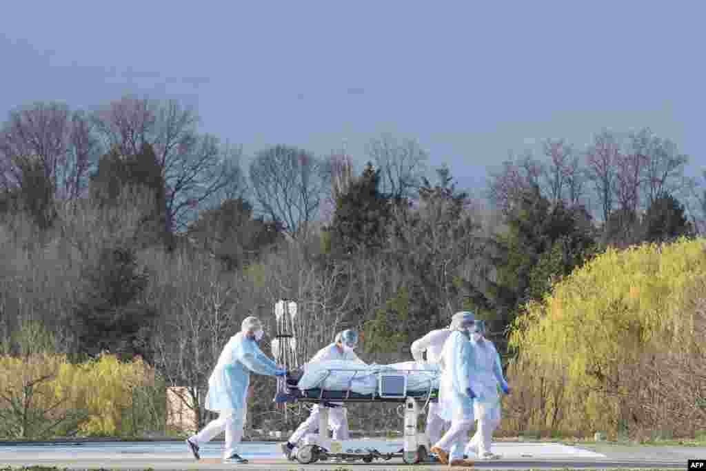 Medical staff push a patient on a gurney to a waiting medical helicopter at the Emile Muller hospital in Mulhouse, eastern France, amid the coronavirus pandemic.
