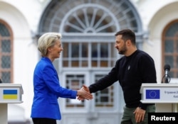 European Commission President von der Leyen and Ukraine's President Zelenskiy shake hands after a joint press conference in Kyiv