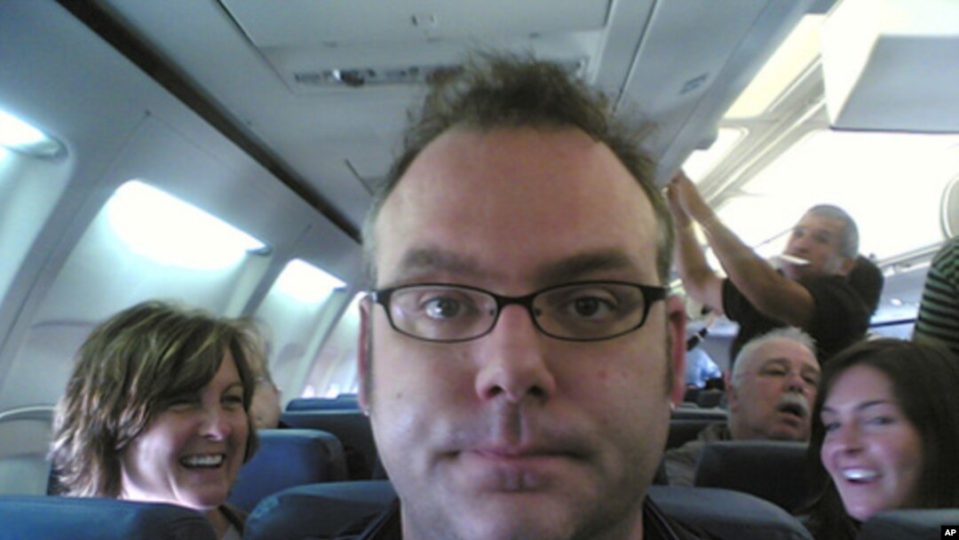 This fellow is clearly THRILLED to have been assigned a center seat.