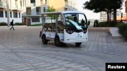 FIE —A worker drives an electrial car at Masdar City in Abu Dhabi, United Arab Emirates, November 6, 2023.