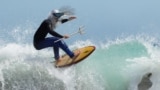 An entrant to the Kommetjie festival's Fancy Dress Surf Competition, going by the title King Neptune, competes in Cape Town, South Africa, Nov. 16, 2024. 