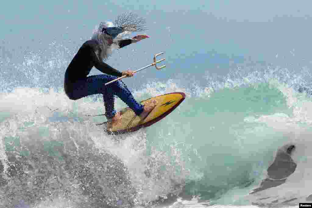 An entrant to the Kommetjie festival's Fancy Dress Surf Competition, going by the title King Neptune, competes in Cape Town, South Africa, Nov. 16, 2024. 