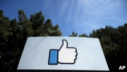 FILE - The thumbs-up Like logo is shown on a sign at Facebook headquarters in Menlo Park, Calif., April 14, 2020. 
