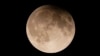 FILE - A supermoon with a partial lunar eclipse rises over Lake Michigan in Chicago, Sept. 17, 2024.