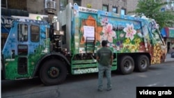 Misha Tytyunik (MDot), seniman Ukraina di New York, berdiri di depan truk sampah yang menjadi kanvas bagi lukisannya. (Foto: videograb)