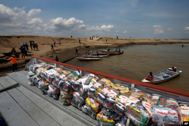 FILE - Packages with food for riverside communities due to the ongoing drought sit on a dock, in Careiro da Varzea, Amazonas state, Brazil on October 24, 2023. (AP Photo/Edmar Barros, File)