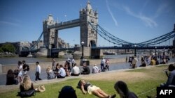 A woman takes a nap in the sunshine at Potters Fields Park near Tower Bridge in central London