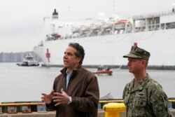New York Gov. Andrew Cuomo, left, speaks as he stands beside Rear Adm. John B. Mustin after the arrival of the USNS Comfort, March 30, 2020, at Pier 90 in New York.