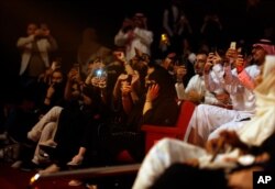 지난해 8월 사우디 남서부 아브하에서 열린 지역 페스티벌에서 남여 관객들이 함께 앉아 공연을 관람하며 스마트폰으로 촬영하고 있다.