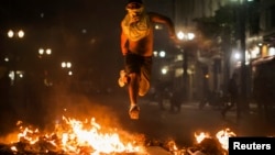 Para demonstran di Sao Paulo, Brazil membakar sampah dan menjarah toko-toko (18/6). 