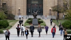 Sejumlah siswa menyeberangi Boulevard Jayhawk di depan Strong Hall di Kampus Universitas Kansas di Lawrence, Kamis, 24 Oktober 2019. (Foto: AP)