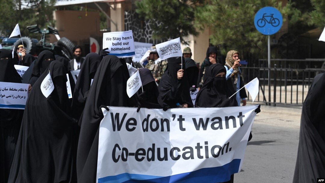 Mujeres cubiertas de la cabeza a los pies marchan por las calles de Kabul, Afganistán, el 11 de septiembre de 2021 en apoyo a las medidas del Talibán de no permitir la educación mixta.