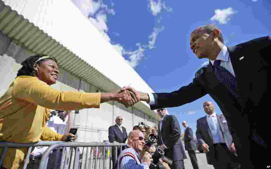 President Barack Obama reaches over to greet supporters on the tarmac at JFK airport in New York, Sept. 24, 2012. 
