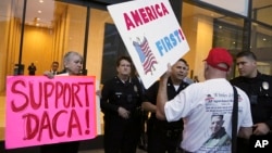 FILE - A supporter of President Donald Trump challenges police officers and a Deferred Action for Childhood Arrivals (DACA) program advocate during a rally outside the office of California Democratic Sen. Dianne Feinstein in Los Angeles, California, Jan. 