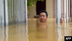 Seorang pria berusaha melewati banjir di luar rumahnya di provinsi Thai Nguyen setelah Topan Yagi melanda Vietnam utara, Selasa 10 September 2024. 