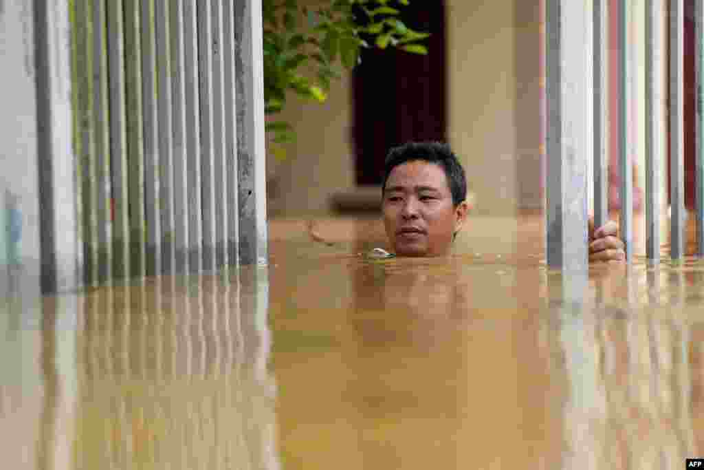 Seorang pria berusaha melewati banjir yang menggenangi rumahnya di provinsi Thai Nguyen setelah Topan Yagi melanda Vietnam utara, Selasa (10/9). Puluhan ribu warga terpaksa dievakuasi atas banjir bandang yang telah menewaskan 82 orang. (AFP)&nbsp;