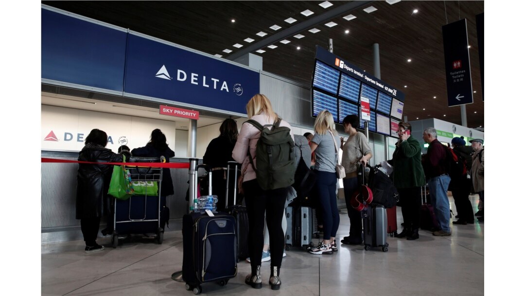 People line up at the Delta Air Lines ticketing desk inside Terminal 2E at Paris Charles de Gaulle airport in Roissy, after the U.S. banned travel from Europe, as France grapples with an outbreak of coronavirus disease, March 12, 2020.