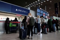 People line up at the Delta Air Lines ticketing desk inside Terminal 2E at Paris Charles de Gaulle airport in Roissy, after the U.S. banned travel from Europe, as France grapples with an outbreak of coronavirus disease, March 12, 2020.