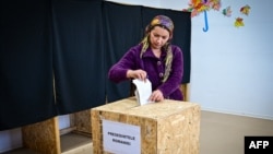 (ARCHIVO) Una mujer deposita su voto para las elecciones presidenciales en un colegio electoral en el pueblo de Galbinasi, Rumania, el 24 de noviembre de 2024. AFP