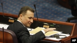 Macedonian Prime Minister Nikola Gruevski gestures, while attending a session in the parliament after resignation of two ministers from Prime Minister's cabinet and a senior state security official, on Wednesday, May, May 13, 2015, in Skopje, Macedonia. 