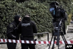 FILE - Greek police set up a security perimeter near the house of Giorgos Karaivaz, a veteran crime journalist, after he was shot dead in Athens, April 9, 2021.