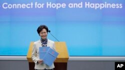 Pemimpin Executive Hong Kong, Carrie Lam, berpose dengan beberapa salinan kebijakannya pada konferensi pers di Hong Kong, 11 Oktober 2017.