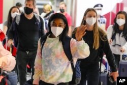Simone Biles, center, and the U.S. Women's Gymnastics team arrive for the Tokyo 2020 Summer Olympic Games at Narita International Airport Thursday, July 15, 2021, in Narita, east of Tokyo. (AP Photo/Kiichiro Sato)