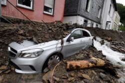 Une voiture est recouverte à Hagen, en Allemagne, mercredi 15 juillet 2021, par les débris apportés par la crue du fleuve Nahma la nuit précédente.