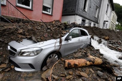 Une voiture est recouverte à Hagen, en Allemagne, mercredi 15 juillet 2021, par les débris apportés par la crue du fleuve Nahma la nuit précédente.