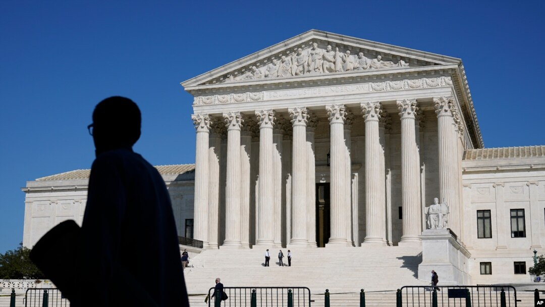 Officials stand on the Supreme Court steps on Capitol Hill in Washington, Tuesday, Sept. 22, 2020, as preparations take place for a private ceremony and public viewing in remembrance of Justice Ruth Bader Ginsburg.