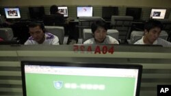 In this photo taken, July 14, 2010, Chinese men use computers at an internet cafe in Beijing, China. China's Twitter-like microblogs are facing new restrictions by the government.